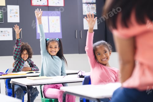 Preview: In school, biracial young woman teaches three young students in classroom