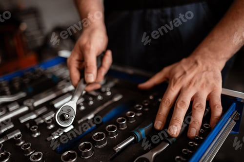 Preview: Hands working with a set of tools in a garage during the afternoon