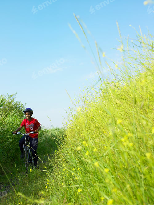 Preview: Boy biking in field of flowers