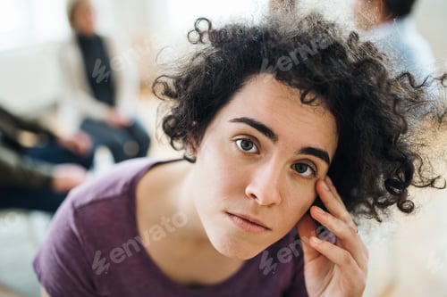 Preview: A portrait of young depressed woman during group therapy.