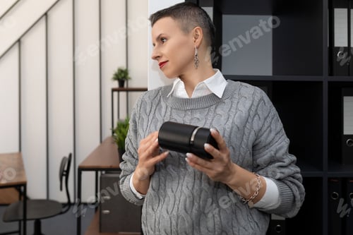Preview: woman accountant with a stamp in her hands on the background of a stylish office