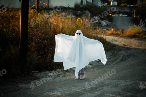 Preview: Child in Ghost Costume Plays Outdoors at Sunset