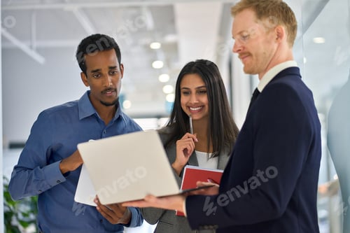 Preview: Busy professional diverse team people standing in office looking at laptop.