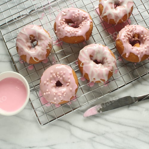 Freshly Made Pink Glazed Donuts on Cooling Rack