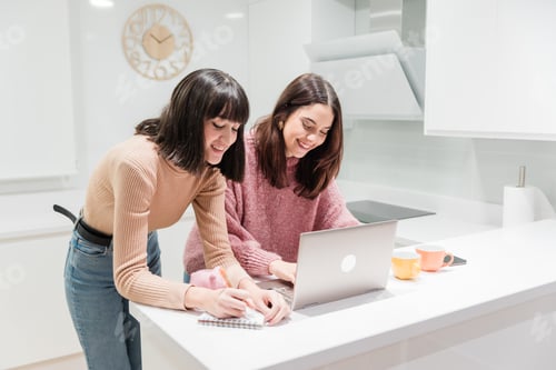 Preview: Smiling Women Working at Kitchen Counter on Laptop