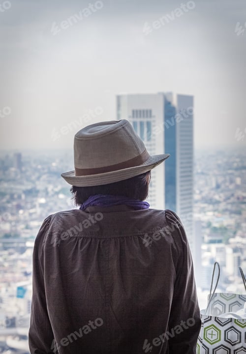 Preview: Japan - May, 10 2013: Anonymous person looking at modern city
