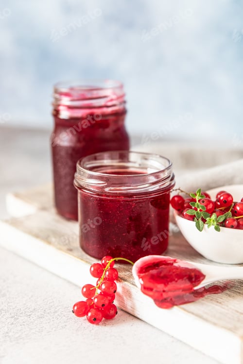 Preview: Homemade red currant jam or jelly in glass jars and red currants fresh berries