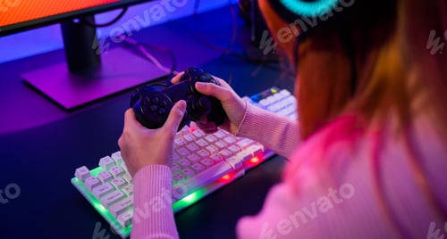 Preview: Woman wear gaming headphones playing live stream esports games console at home