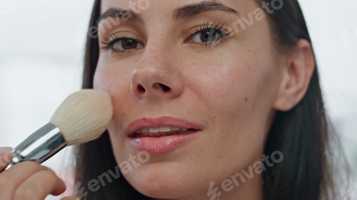 Preview: Portrait model applying powder home. Smiling woman putting blushes making makeup