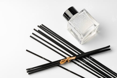 Preview: A minimalist display of essential oil and black diffuser sticks on a clean white background