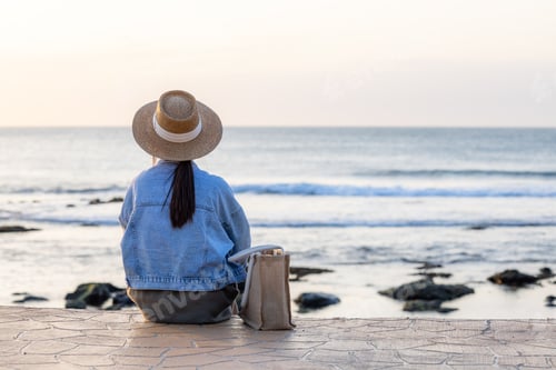 Preview: Tourist woman sit at the seaside under sunset period