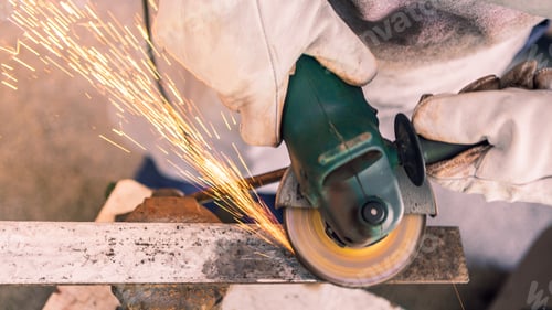 Preview: Metal processing with a man using angle grinder to cleaning the steel seam.