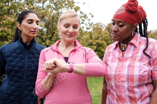 Preview: Mature fitness women checking smart watch