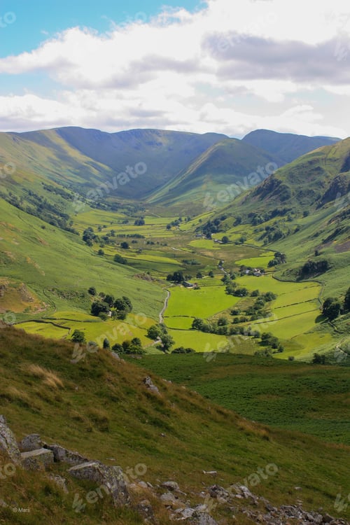 Preview: Lush green valley with a patchwork of rolling hills and lush grassy fields.