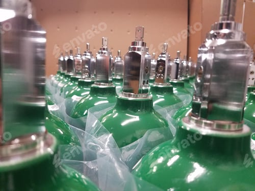 Preview: Closeup shot of many green high-pressure cylinders covered by plastic