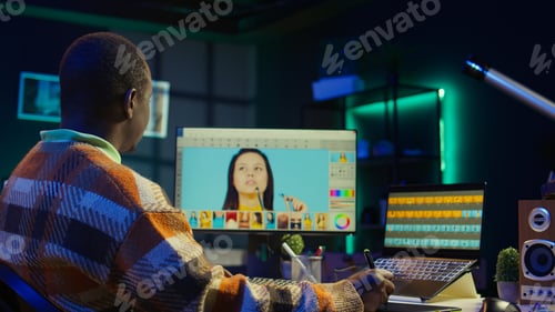 Preview: African american photo designer retouching images on dual monitors