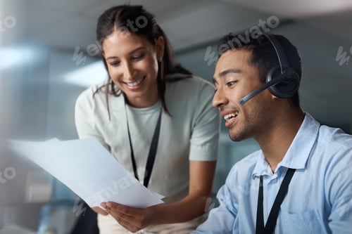 Preview: Shot of a young man and woman reading a document while working in a call centre
