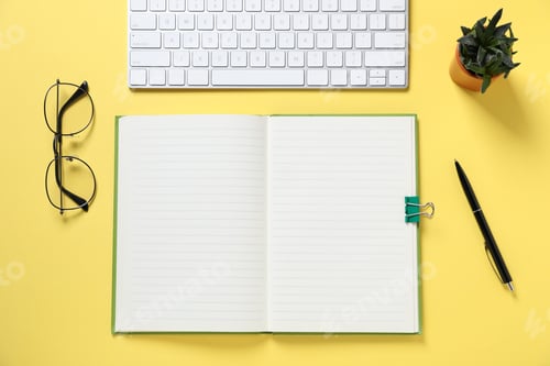 Preview: Open blank notebook, computer keyboard, glasses, pen and floral decor on yellow background, flat lay