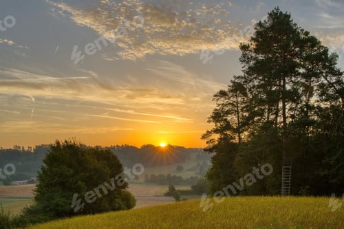 Preview: Sunrise over serene countryside landscape.