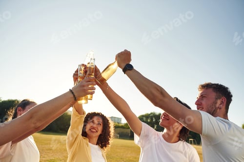 Preview: Party time, celebration. People are celebrating by cheering with beer bottles