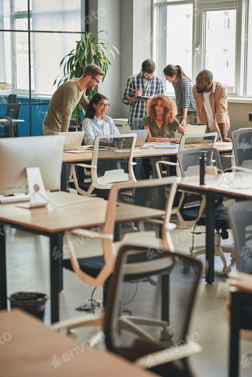 Preview: Strong team of young professionals working together in modern office