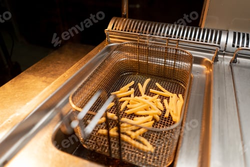 Preview: professional kitchen in the hotel restaurant chef takes out delicious french fries from the fryer
