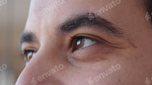 Preview: Close-up of brown eyes of man looking into distance. Action. Man with bright brown eyes looks with