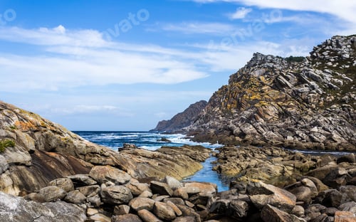 Preview: a body of water surrounded by rocky shores with large rocks