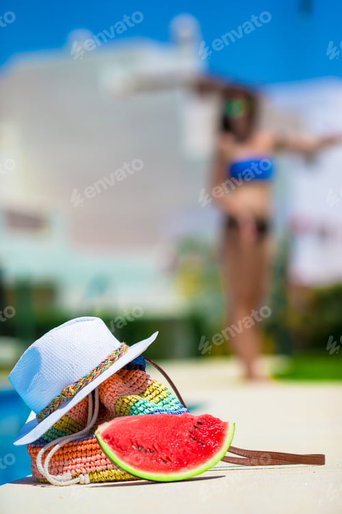 Preview: Summer concept- tasty watermelon, straw bag and juice near pool outdoor background young woman