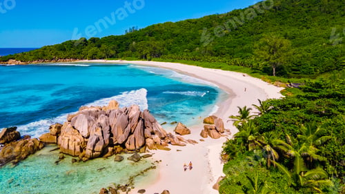 Preview: Anse Cocos La Digue Seychelles, young couple men and woman on a tropical beach during a luxury
