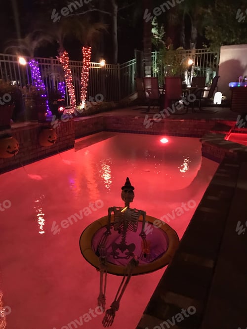 Preview: A skeleton floats in the red pool for an outdoor Halloween party
