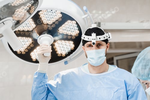 Preview: Male surgeon adjusts operating light for surgical procedure in medical clinic