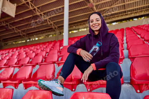 Preview: Smiling Woman Staying Hydrated at Outdoor Sports Venue