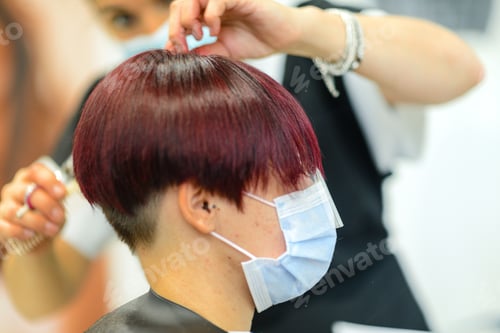 Preview: Closeup shot of a female getting her hair done wearing a face mask - concept of the new normal