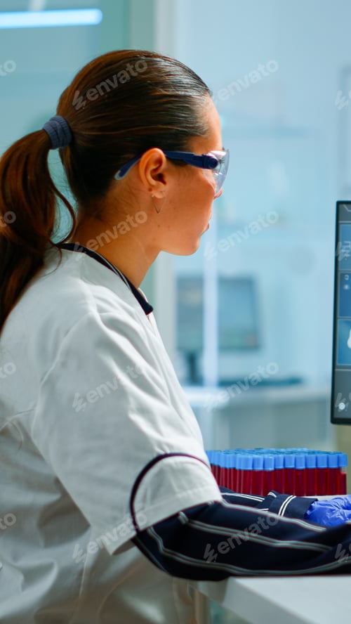 Preview: Biologist doctor checking DNA informations typing on pc