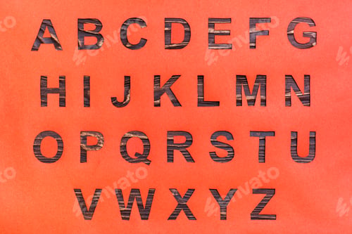 Preview: The letters of the English alphabet are carved from red cardboard, a wooden background