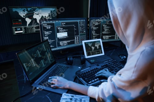 Preview: Young professional female hacker is indoors by computer with lot of information on displays