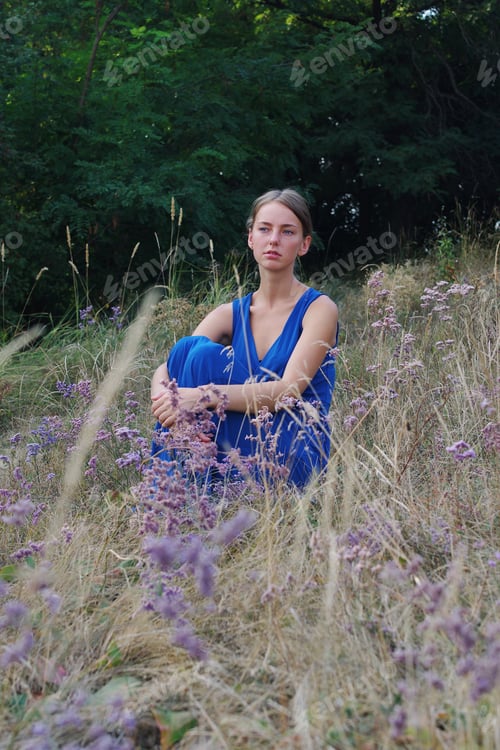 Preview: Woman Sitting in Field of Wildflowers