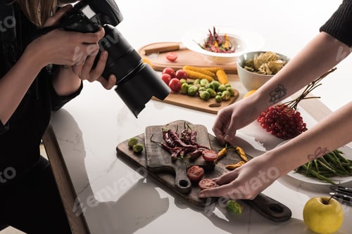 Preview: cropped view of commercial photographers making photo shoot of food on digital camera