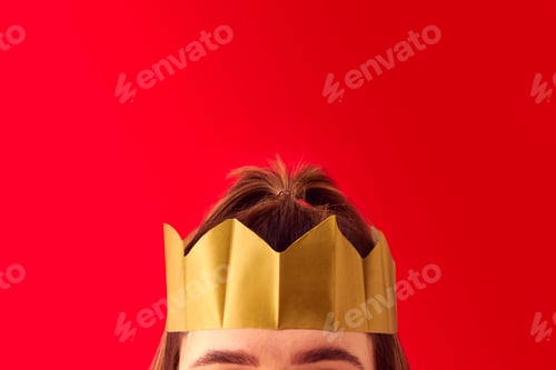 Preview: Close Up Studio Shot Of Woman Wearing Christmas Paper Crown Hat Against Red Background
