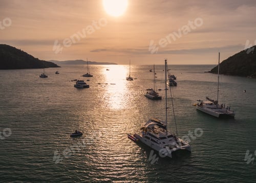 Preview: G\roup of private yacht sailing on tropical sea at the sunset