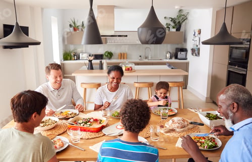 Preview: Multi-Generation Mixed Race Family Eating Meal Around Table At Home Together