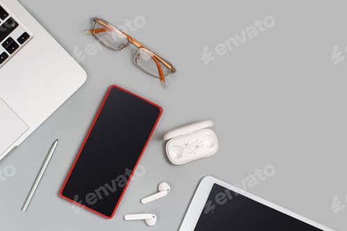 Preview: Laptop, tablet, Mobile phone, earphones and glasses on grey desk