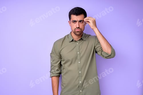 Man Wearing Green Shirt With Hand on Head