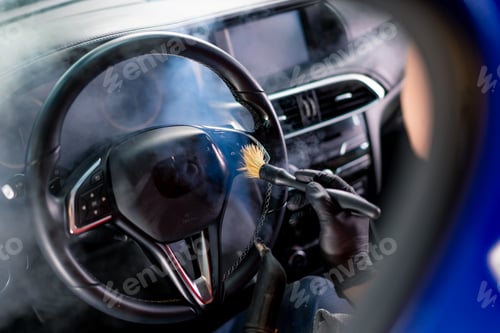 Preview: A car wash worker carefully cleans the interior of a luxury car with a rag a brush a vacuum cleaner