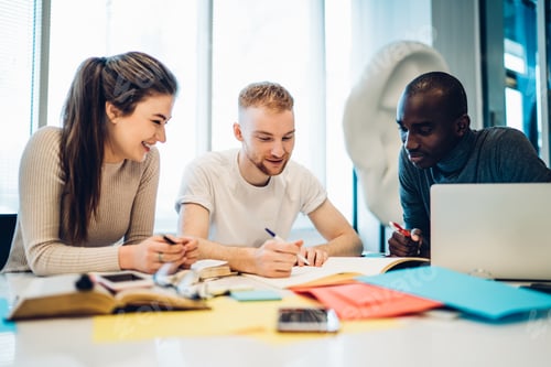 Preview: Joyful multiethnic colleagues working together at table