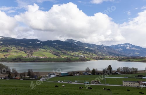 Preview: mountainous landscape in Switzerland covered with snow and partly in the clouds with Greyerzersee