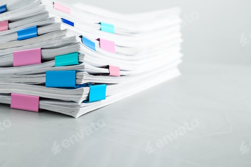 Preview: Stack of documents with binder clips on light table