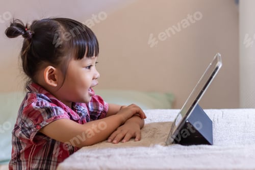 Preview: Young Child Engaged with Tablet Device Indoors