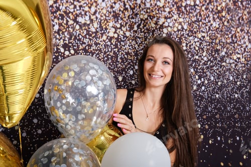 Preview: Beautiful happy womanamong party balloons